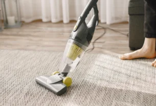 Aspirador vertical Electrolux limpando tapete com reservatório transparente visível - eficiência em carpetes