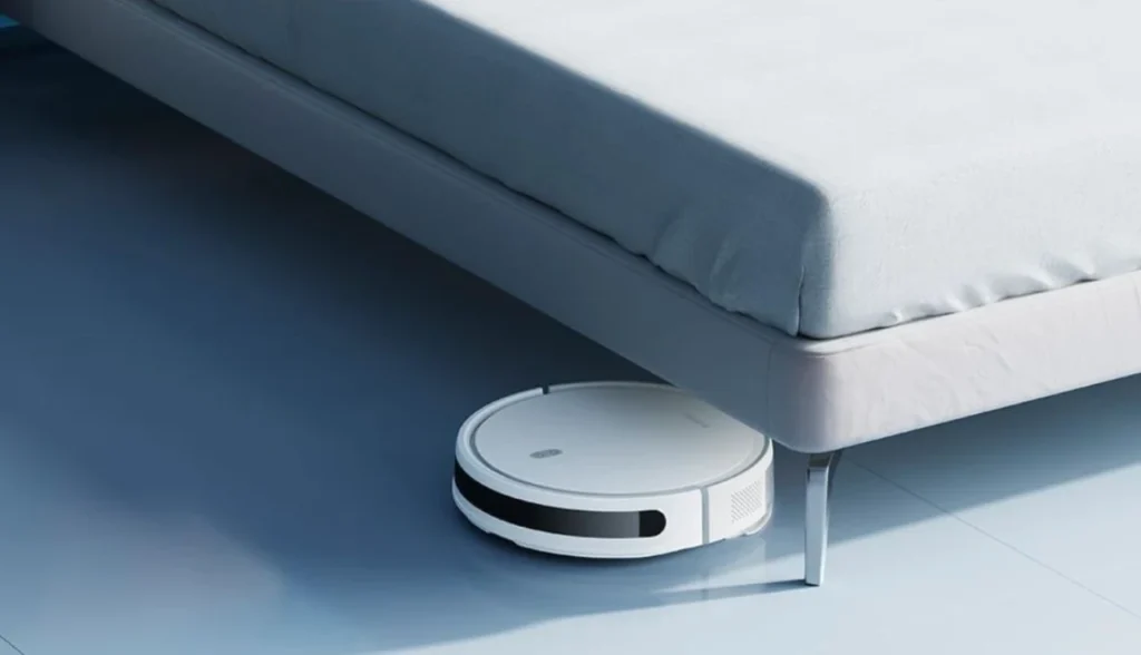 "Robô aspirador Xiaomi Mi Robot Vacuum E10 branco limpando debaixo de sofá moderno em ambiente minimalista"