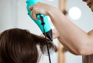 Mulher usando Secador Taiff Stylle 2000w para secar cabelo longo, demonstrando potência e facilidade de uso