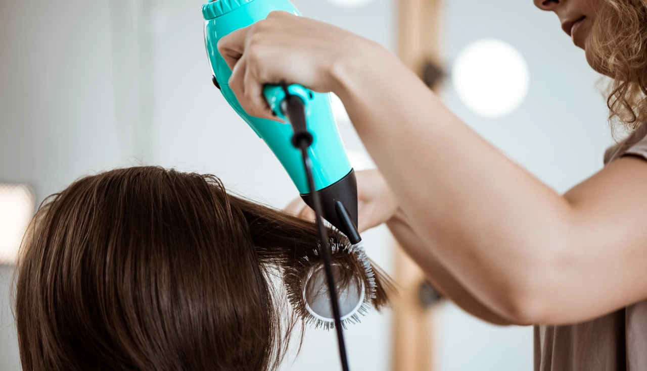 Mulher usando Secador Taiff Stylle 2000w para secar cabelo longo, demonstrando potência e facilidade de uso